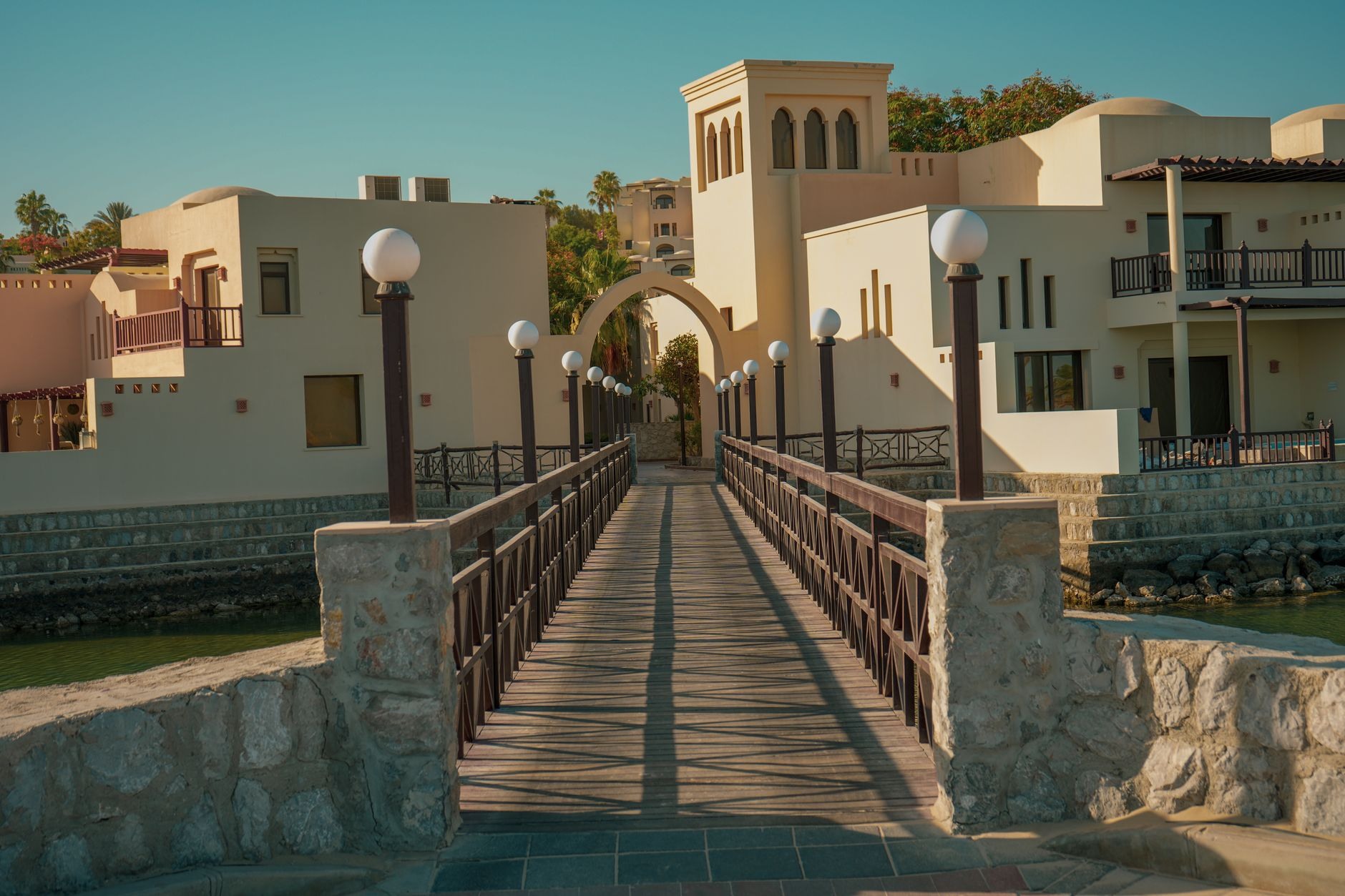 Twilight desert resort with stone facades and warm lantern lighting at Stone Hall